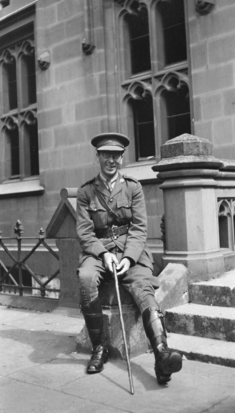A full-length portrait of Professor Robert Strahan Wallace, Professor of English Language and Literature, dressed in an Australian Imperial Forces uniform and seated in front of a Melbourne University building, 1918. Photo taken by Doris McKellar, a student at that time. University of Melbourne Archives, Doris McKellar collection